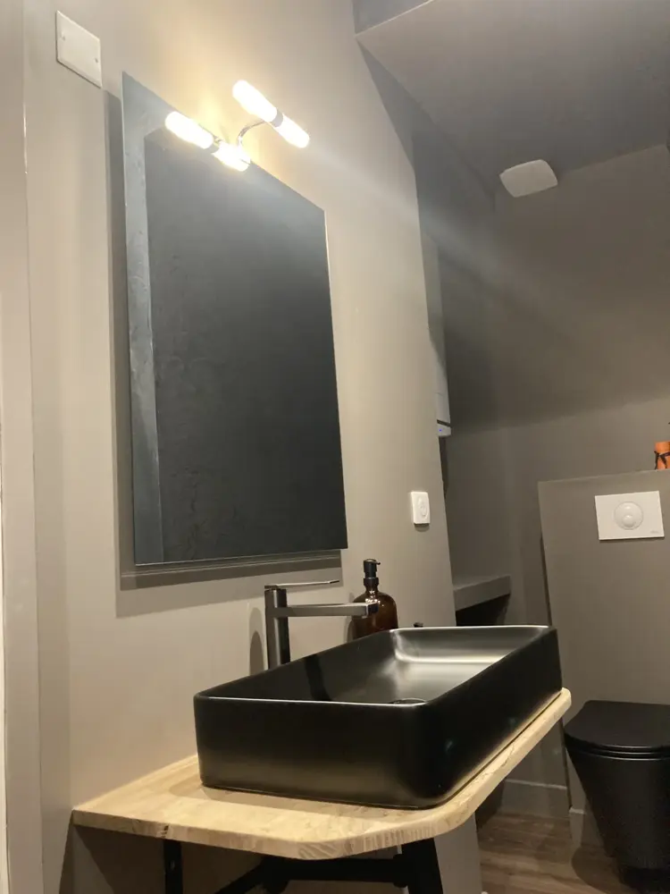 Salle d’eau avec vasque noire et miroir