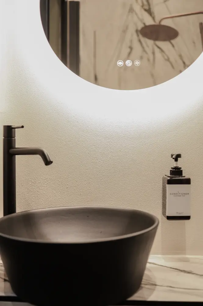 Lavabo nero e specchio tondo retroilluminato